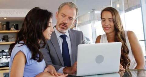 Business Professionals Having Meeting with Laptop in Cafe