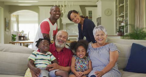 a cheerful extended family is gathered on a comfortable couch in a cozy living room, radiating warmth and togetherness. this wholesome scene highlights the joy of family life across generations. useful for family-oriented articles, lifestyle campaigns, or advertisements promoting family values.