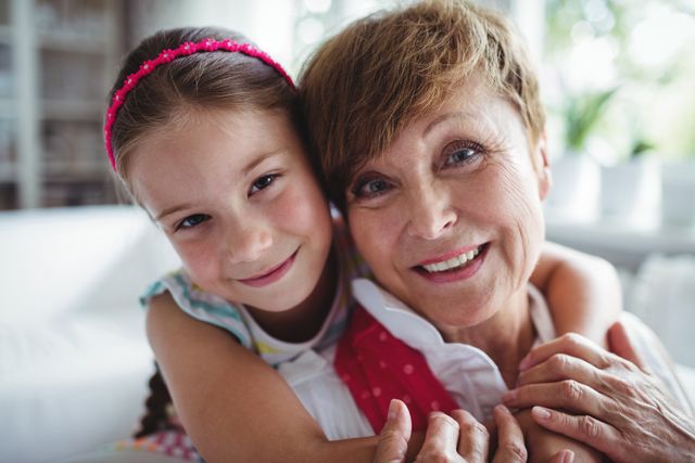Portrait of granddaughter embracing her grandmother at home