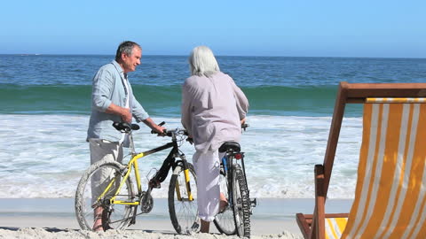 Senior Couple with Bicycles Enjoying Beach