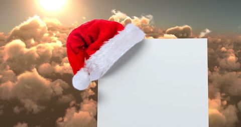 Santa Hat on Blank Card with Sunset Cloudscape Background