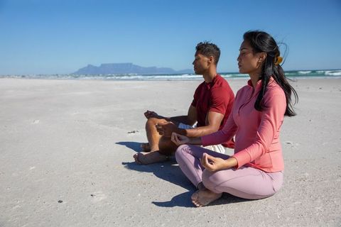 Diverse Couple Meditating on Serene Sandy Beachfront
