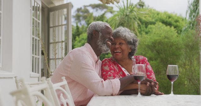 Joyful Senior Couple Enjoying Wine on Sunny Patio - Download Free Stock Images Pikwizard.com