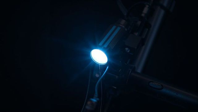 Round LED Bicycle Headlight Emitting Cool White Beam on Handlebar at Night