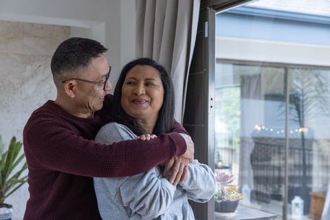 Affectionate Senior Couple Embracing in Cozy Living Room
