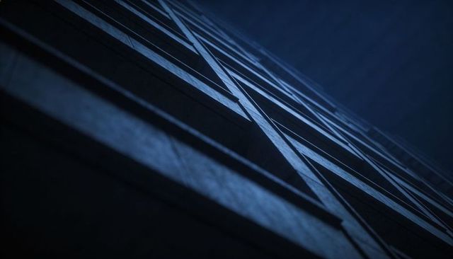 Urban highrise facade rising with diagonal shadows and geometric blue panels
