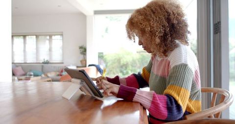 Focused Woman Using Tablet While Working at Home