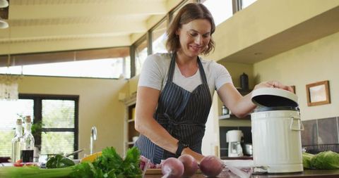 Pregnant woman cooking in kitchen and preparing meal with organic vegetables