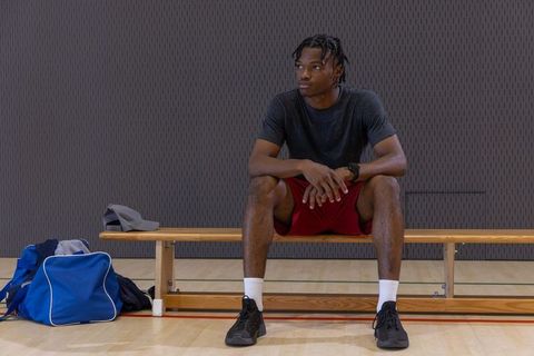 African american athlete sitting on bench in gym preparing for intense workout and training focus