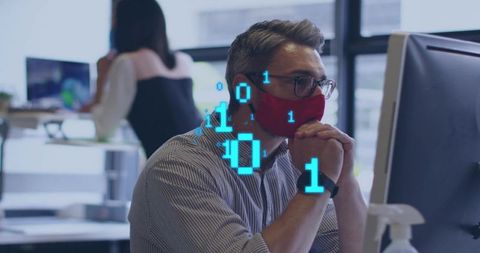 Mature professional wearing red face mask focusing on monitor with digital binary overlay