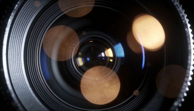 Macro camera lens close-up showing aperture, bokeh reflections and coated glass elements