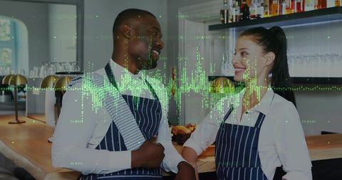 Smiling cafe staff chatting behind counter in navy aprons with green data waveform overlay