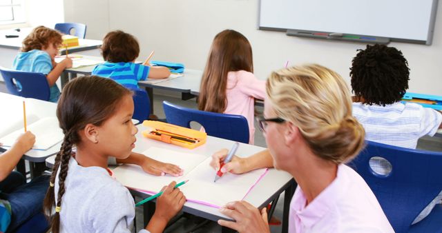 Teacher Helping Children in Classroom During Lesson - Download Free Stock Images Pikwizard.com