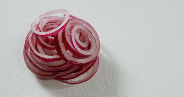 Close up of cut in circles fresh red onion on white table. Health, diet and food.