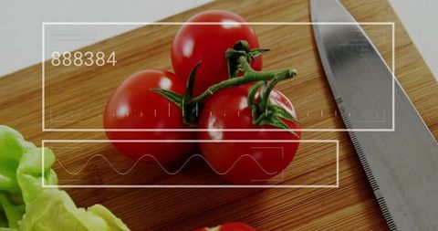 Fresh vine tomatoes resting on wooden cutting board with chef knife and hud overlay