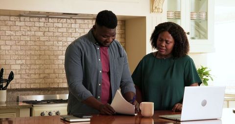 Mature Couple Reviewing Documents Together in Kitchen
