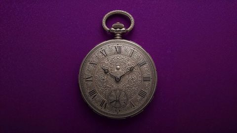 Intricate british empire vintage pocket watch on royal purple background