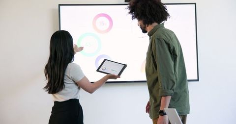 Multicultural team analyzing business data on shared screen collaboratively