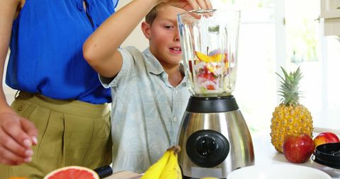 Family Bonding Making Fresh Fruit Smoothies Together in Kitchen