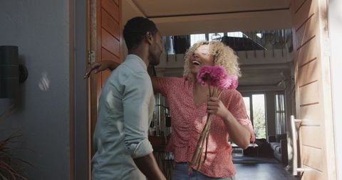 Happy Couple Entering Modern Home with Bouquet