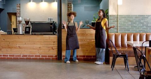 Two african american baristas welcoming customers in modern coffee shop interior casual teamwork