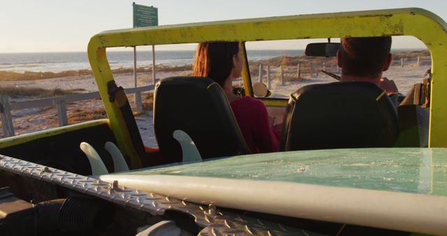Couple driving an open-top off-road vehicle on a quiet beach during sunset. Featuring sandy beach, clear sky, and relaxed atmosphere. Use this for travel blogs, adventure tourism promotions, romantic getaways, or summer vacation advertisements.