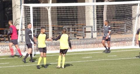 Youth soccer players practicing teamwork on field in uniforms