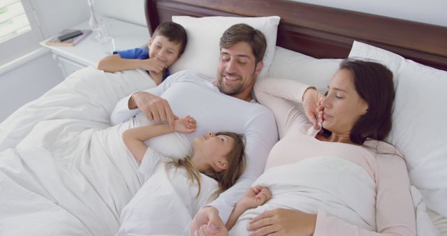 Happy Family Enjoying Time in Bed Together - Download Free Stock Images Pikwizard.com