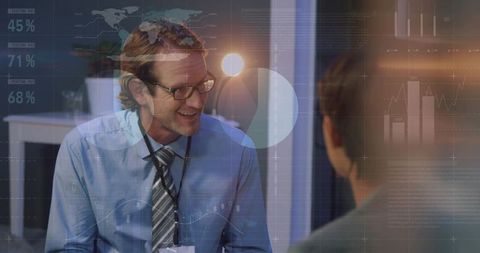Smiling businessman leading data-driven discussion with charts overlay and teamwork