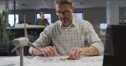 Engineer Planning Wind Energy Projects in Office