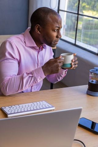 Man Reflecting in Modern Home Office with Coffee