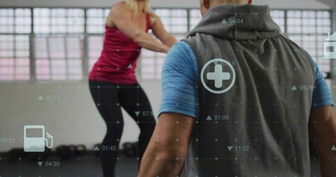 Trainer coaching woman performing squat in industrial gym with digital fitness hud overlay