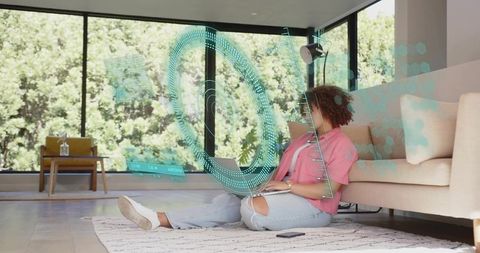 Working woman using laptop with holographic hud in sunlit minimalist living room