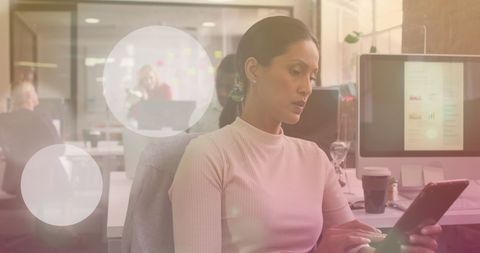 Focused biracial businesswoman using tablet in modern office