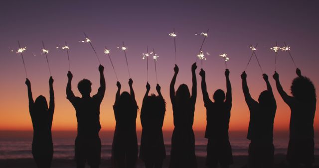 Group of Friends Celebrating with Sparklers at Sunset Beach - Download Free Stock Images Pikwizard.com