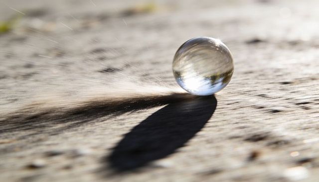 Crystal sphere refracting sunlight on weathered wood with long shadow and motion blur