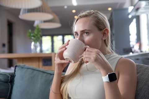 Woman relaxing with ceramic mug in modern home