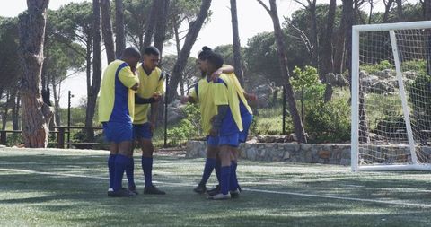 Youth Soccer Team Celebrating Victory on Field with High Fives