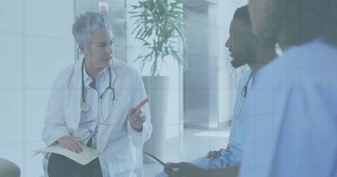 Doctor consulting with medical team in hospital corridor