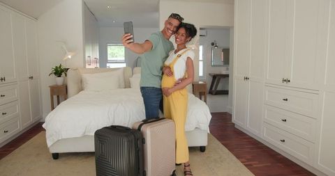 Diverse Couple Preparing for Vacation with Packed Suitcases in Bedroom