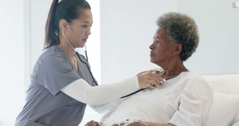 Nurse Checking Heartbeat of Senior Patient in Hospital Room