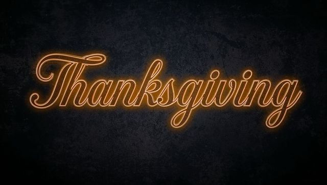 Thanksgiving Neon Script Sign Glowing Amber Cursive Typography on Dark Textured Wall