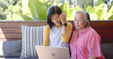 Asian Mother and Daughter Collaborating on Laptop