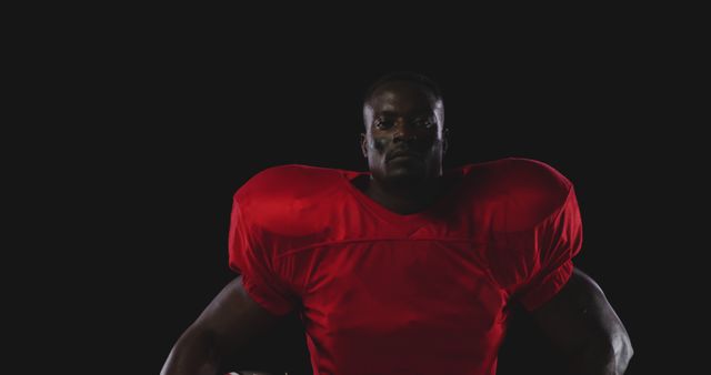 Confident American Football Player in Red Uniform against Dark Background - Download Free Stock Images Pikwizard.com