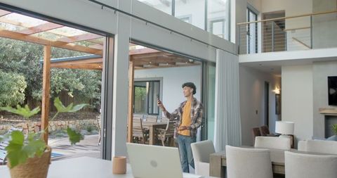 Relaxed Man Using Smartphone in Modern Home Interior
