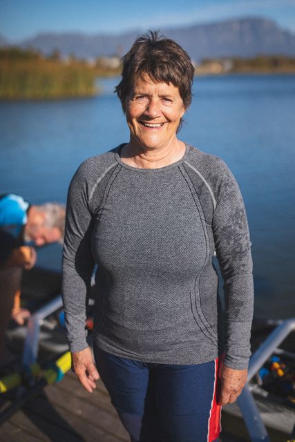 Portrait of senior caucasian woman from rowing club smiling to camera by the river. senior sports hobby, active retirement lifestyle.