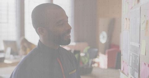 Professional Reviewing Office Plans on Brick Wall with Sticky Notes