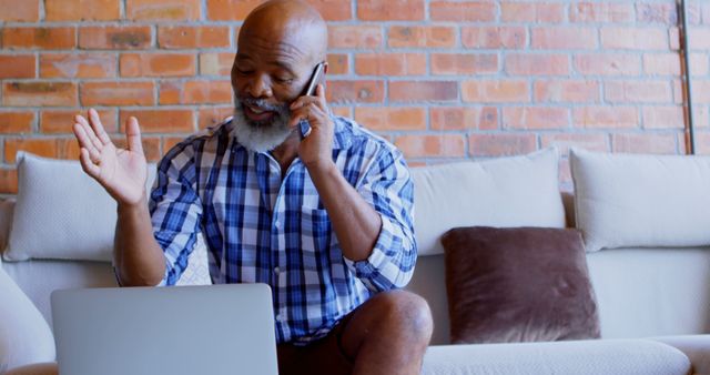 Senior Man Communicating via Phone and Laptop at Home - Download Free Stock Images Pikwizard.com