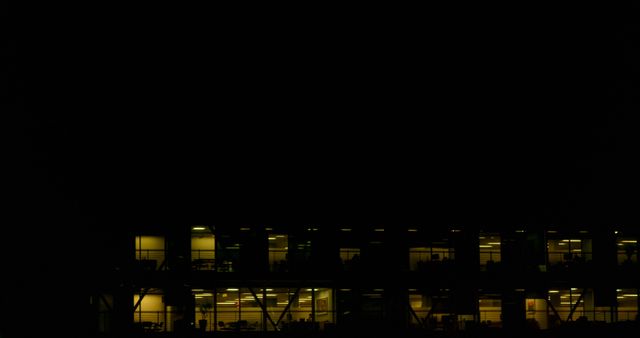 Office building with lighted windows during night. Useful for depicting corporate culture, late-night work practices, and the hustle of business environments. Suitable for articles about modern work ethics, business strategies, and office life.