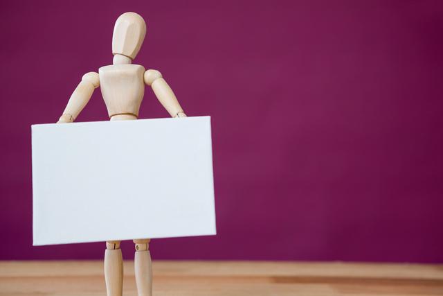 Conceptual image of figurine holding blank placard